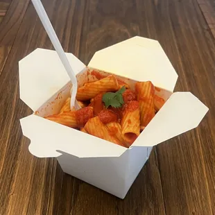 ows a takeout box of pasta