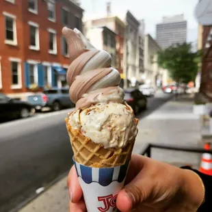 ows a hand holding a cone of ice cream