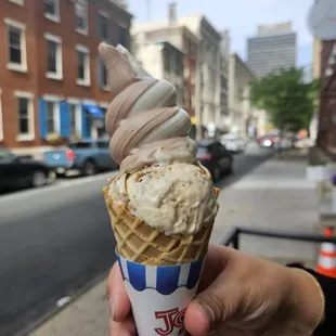 ows a hand holding a cone of ice cream