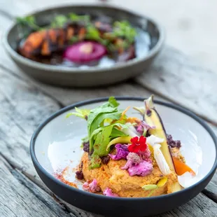 two plates of food on a wooden table