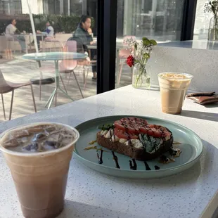An iced mocha, hummus toast, and an iced vanilla latte.
