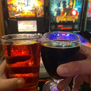 two people holding glasses of beer