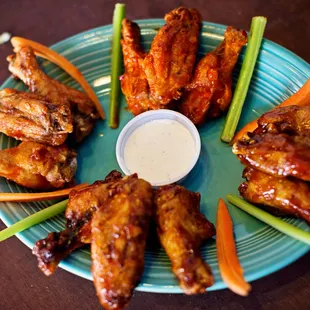 a plate of chicken wings and carrots
