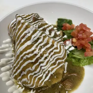 Chimichanga smothered in pork green chile with sour cream drizzled on top.