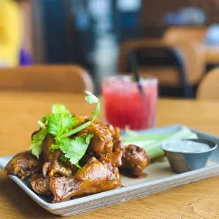 a plate of chicken wings with a side of celery