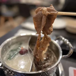 a bowl of soup and a chopstick