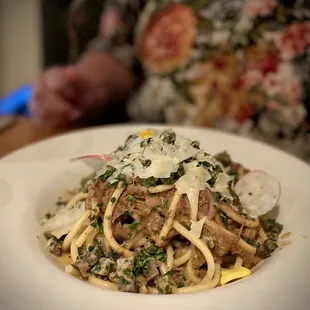 a plate of spaghetti with meat and vegetables