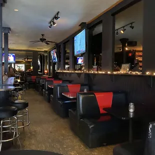 a bar with black and red booths