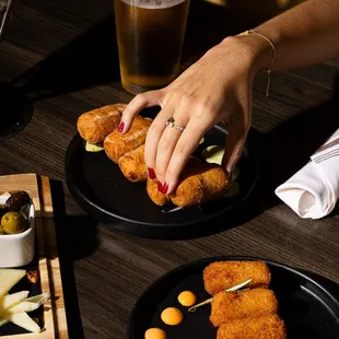 a person grabbing a piece of food from a plate