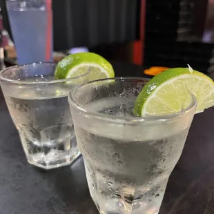 two glasses of vodka with lime wedges