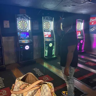 a man standing in front of a bowling machine