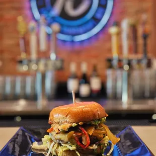 a burger on a plate with a bar in the background
