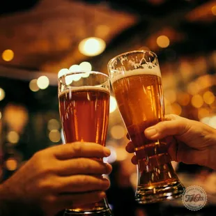 two people toasting with beer glasses