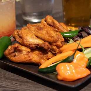 a plate of chicken wings and vegetables