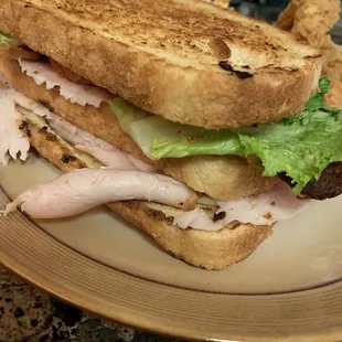 The clubhouse sandwich on sourdough.  It&apos;s a thick bubba, you&apos;re gonna have to open wide to take a bite.