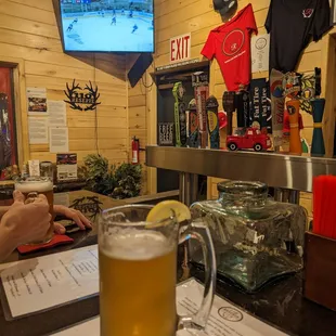 a man sitting at a bar with a glass of beer
