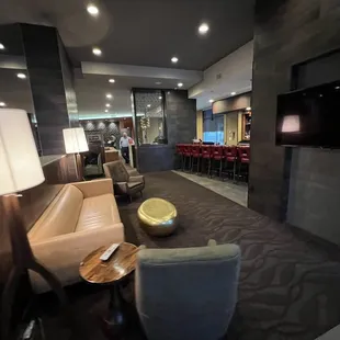 a hotel lobby with seating and a flat screen tv