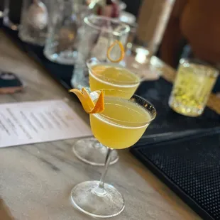 a row of cocktails on a bar