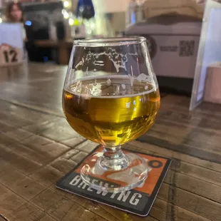 a glass of beer on a coaster