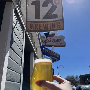 a hand holding a glass of beer