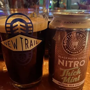 a glass of beer and a can of new trail