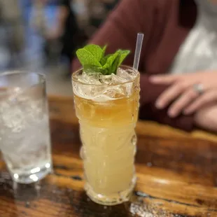 a tall glass with a mint leaf garnish