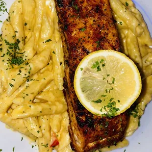 a plate of pasta and a piece of salmon