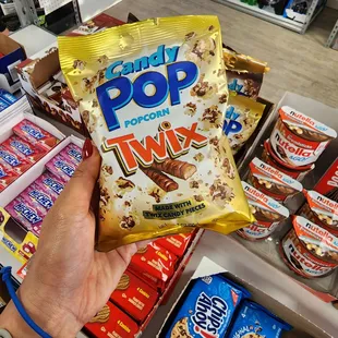 a hand holding a bag of candy pop