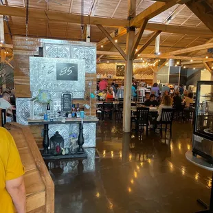 a man in a yellow shirt standing at a bar