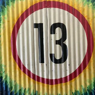 the number thirteen painted on a corrugated wall
