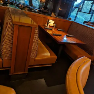 a corner booth with a table and chairs