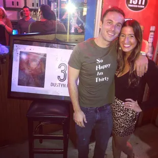 a man and a woman standing in front of a tv