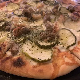 a pizza with meatballs and cucumbers