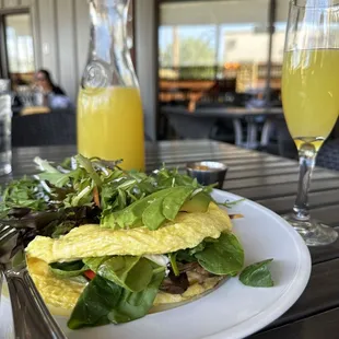 a plate of food and a glass of orange juice