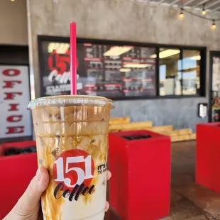 a hand holding a cup of iced coffee