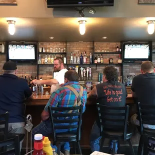 a group of men sitting at a bar