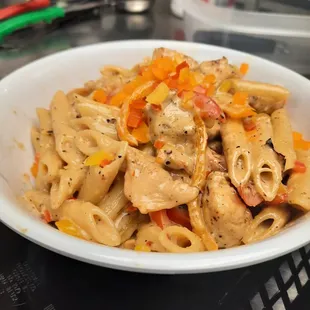 a bowl of pasta with chicken and peppers