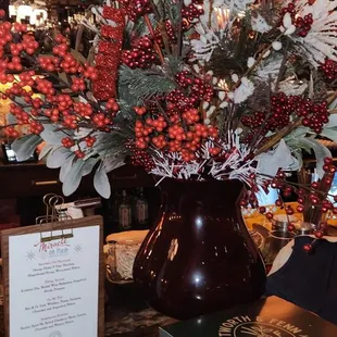 a vase of red berries and greenery
