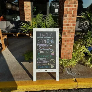 a chalkboard sign in front of a coffee shop