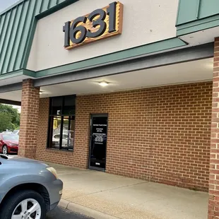 the front of a building with a car parked in front of it