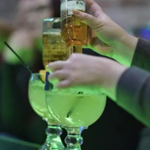 a close up of a person's hand holding a glass of beer