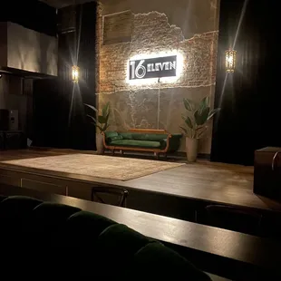 an empty stage with a green couch