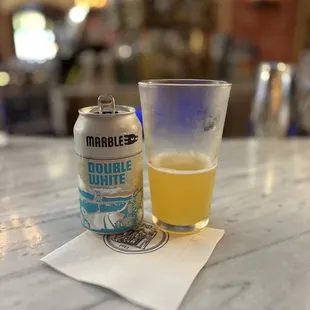a can of double white and a glass of beer