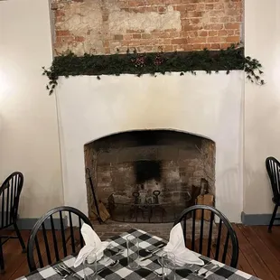 a table setting with a fireplace in the background