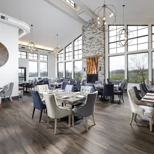 a dining room with a fireplace and large windows