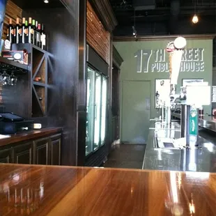 The view from the right side of the bar. There is a flat screen tv to the left if the bottles on the upper left side.