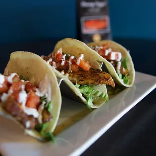 three tacos on a white plate