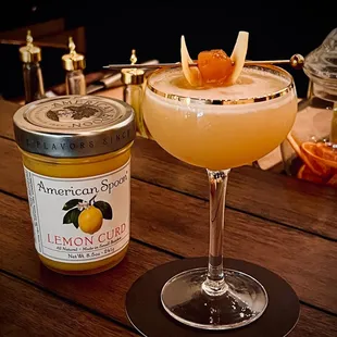 a glass of lemon curd next to a jar of lemon curd