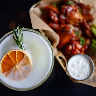 a drink with a slice of orange and celery