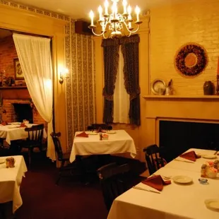 a dining room with a fireplace and chandelier